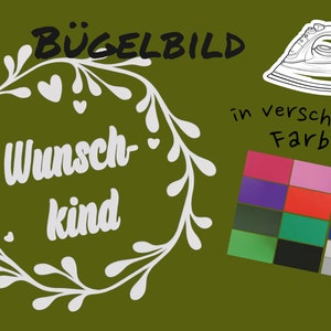 May include: Iron-on transfer design featuring a wreath with the text "Wunsch-kind" in white on a green background. The design is available in various colors.