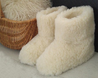 May include: A pair of white sheepskin slippers with a fluffy texture. The slippers are made of soft, natural materials and are perfect for keeping your feet warm in the winter.