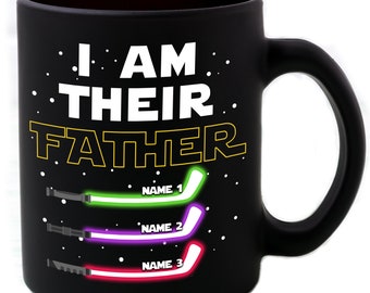 Puede incluir: Taza de café negra con el texto "I AM THEIR FATHER" en blanco con un contorno amarillo. Tres sables de luz con los nombres "NAME 1", "NAME 2" y "NAME 3" están debajo del texto.