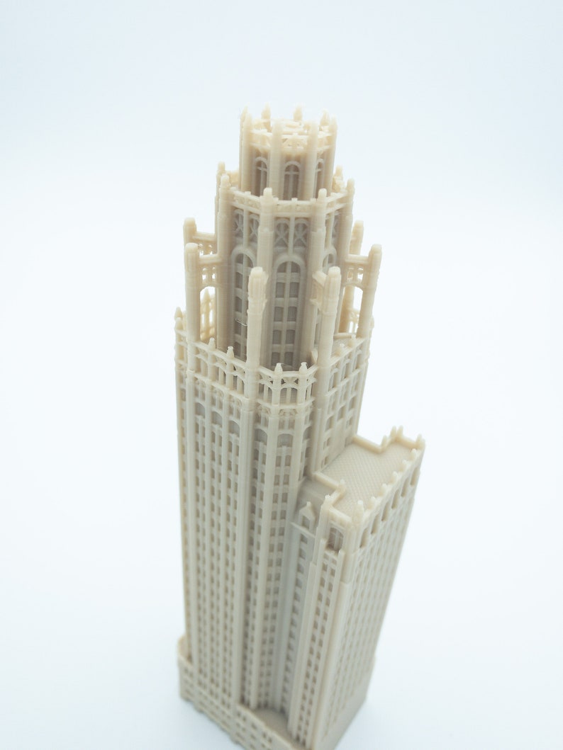 May include: A detailed 3D printed model of a tall, beige building with a decorative top and many windows.