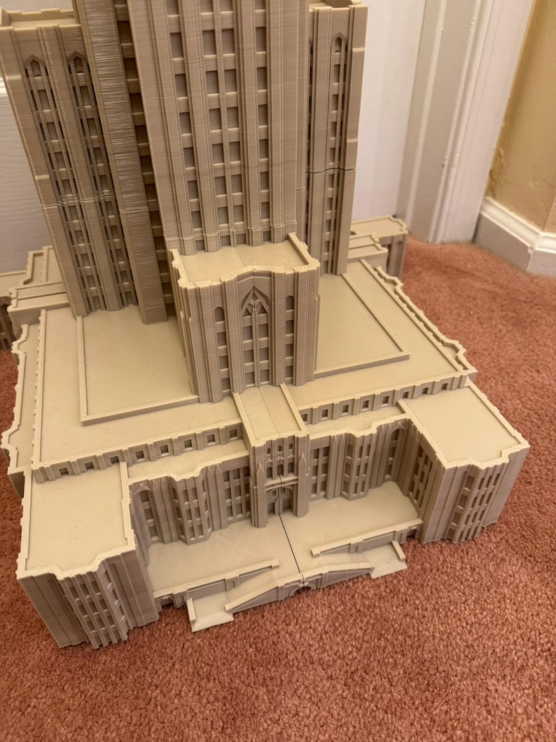 Puede incluir: Un modelo detallado de un edificio alto con un techo plano y una gran entrada. El edificio est&aacute; hecho de un material marr&oacute;n claro y tiene muchas ventanas. El modelo est&aacute; sentado sobre una alfombra marr&oacute;n.