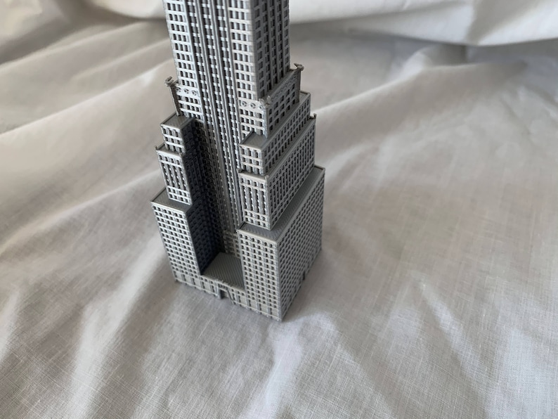 Puede incluir: Un modelo gris de un rascacielos con muchas ventanas y detalles. El modelo est&aacute; hecho de pl&aacute;stico y mide aproximadamente 25 cm de alto.