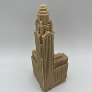 May include: A beige 3D printed model of a tall building with a decorative top and many windows.