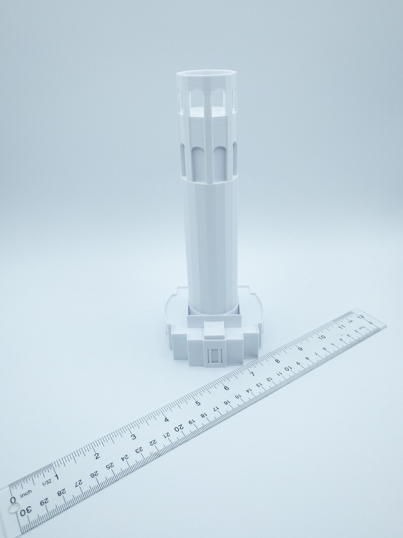 Może przedstawiać: Biały model 3D wydrukowany w 3D ikonicznego zabytku San Francisco, wieży Coit. Model ma około 15 cm wysokości i jest pokazany obok linijki w celu skalowania.