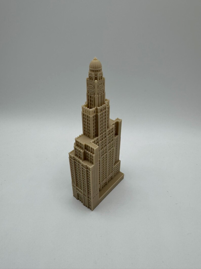 May include: A detailed miniature model of a tall, beige building with a domed roof and a clock face. The model is made of plastic and has a realistic design.