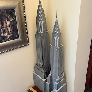 Puede incluir: Una maqueta plateada del edificio Chrysler en la ciudad de Nueva York. La maqueta est&aacute; hecha de pl&aacute;stico y mide aproximadamente 30 cm de alto. Es una r&eacute;plica detallada del edificio, incluyendo la aguja y los detalles Art Deco.