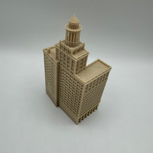 May include: A beige 3D printed model of a tall building with a domed roof and many windows.