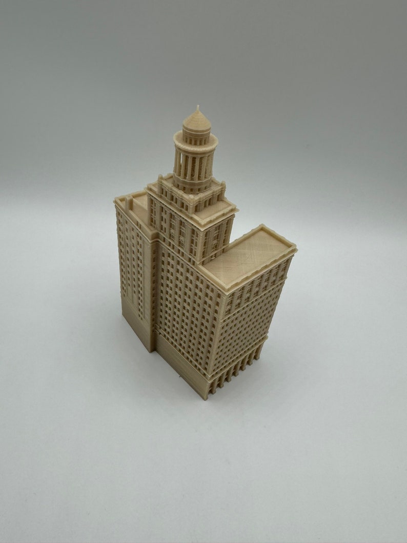 May include: A beige 3D printed model of a tall building with a domed roof and many windows.