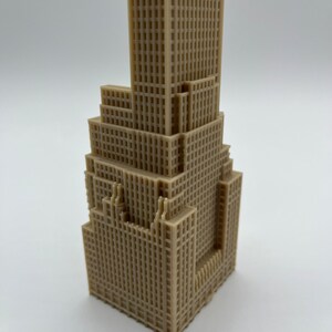 May include: A beige 3D printed model of a skyscraper with a detailed facade.