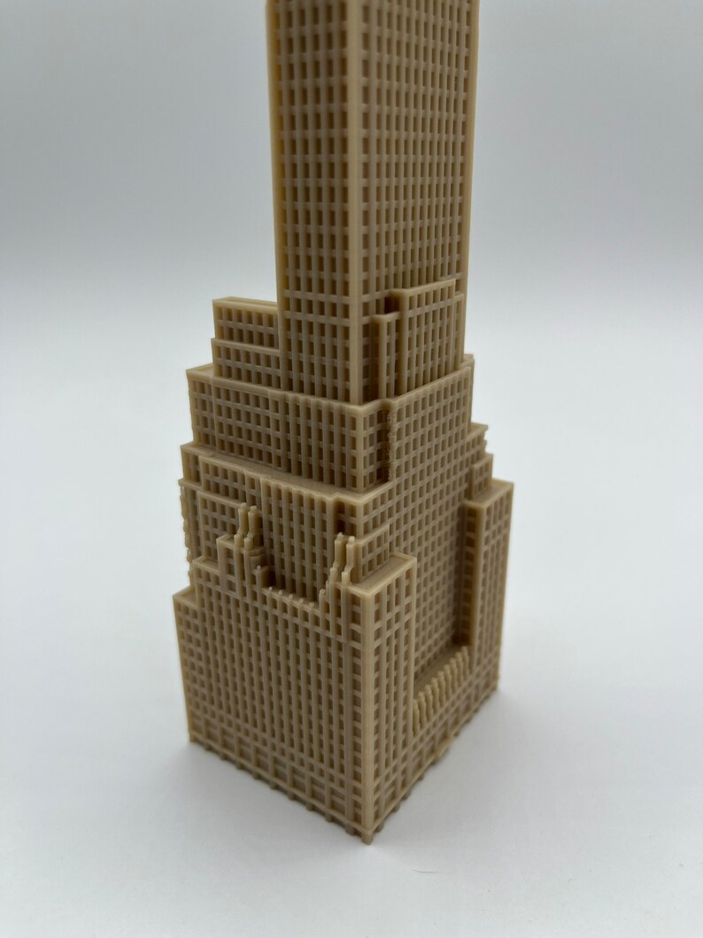 May include: A beige 3D printed model of a skyscraper with a detailed facade.