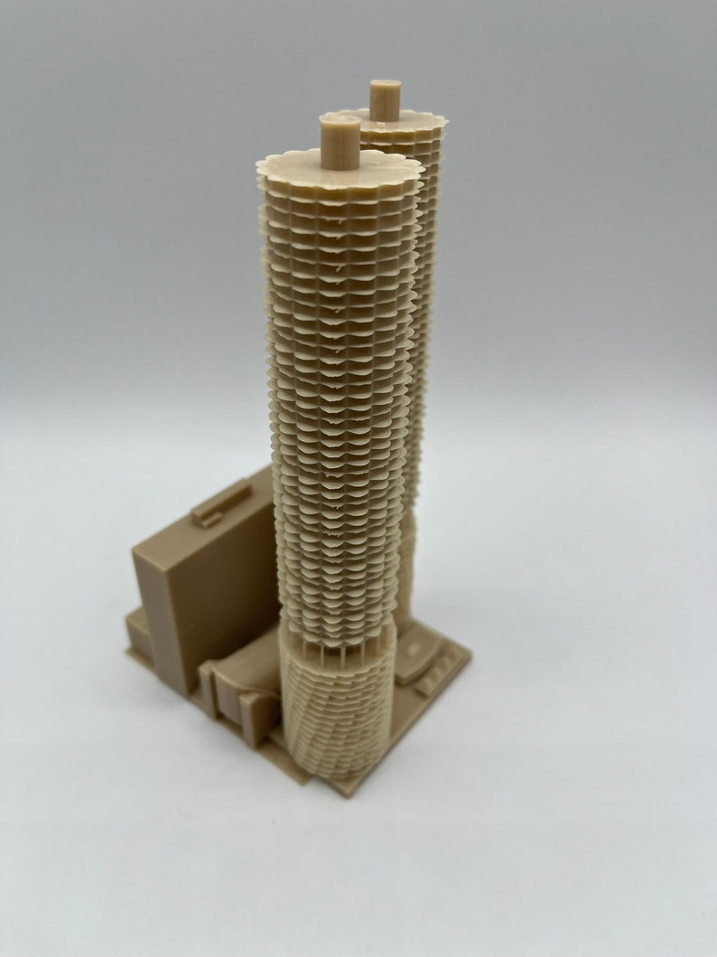 May include: A beige 3D printed model of a skyscraper with a unique honeycomb design.