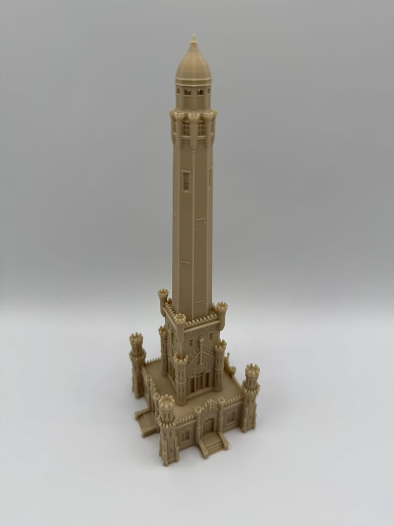 May include: A beige 3D-printed model of a tall, ornate tower. The tower has a detailed architectural design with multiple levels, windows, and decorative elements. The model is standing on a square base with four corner turrets.