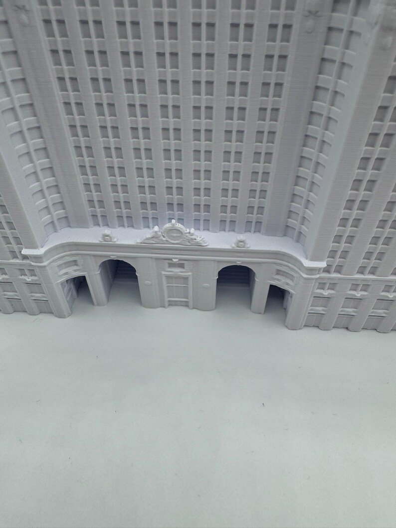 Puede incluir: Maqueta arquitect&oacute;nica blanca de un edificio con numerosas ventanas y entradas arqueadas. El modelo muestra detalles intrincados, incluyendo elementos decorativos sobre la entrada y a lo largo de la fachada. El dise&ntilde;o del edificio sugiere un estilo cl&aacute;sico e hist&oacute;rico.