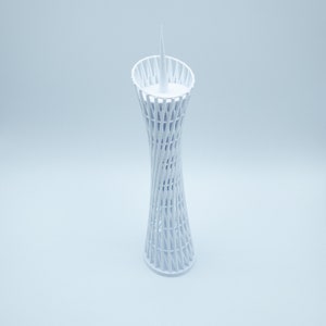 May include: White 3D printed model of a tall, slender tower with a lattice design. The tower has a pointed top and a circular base.