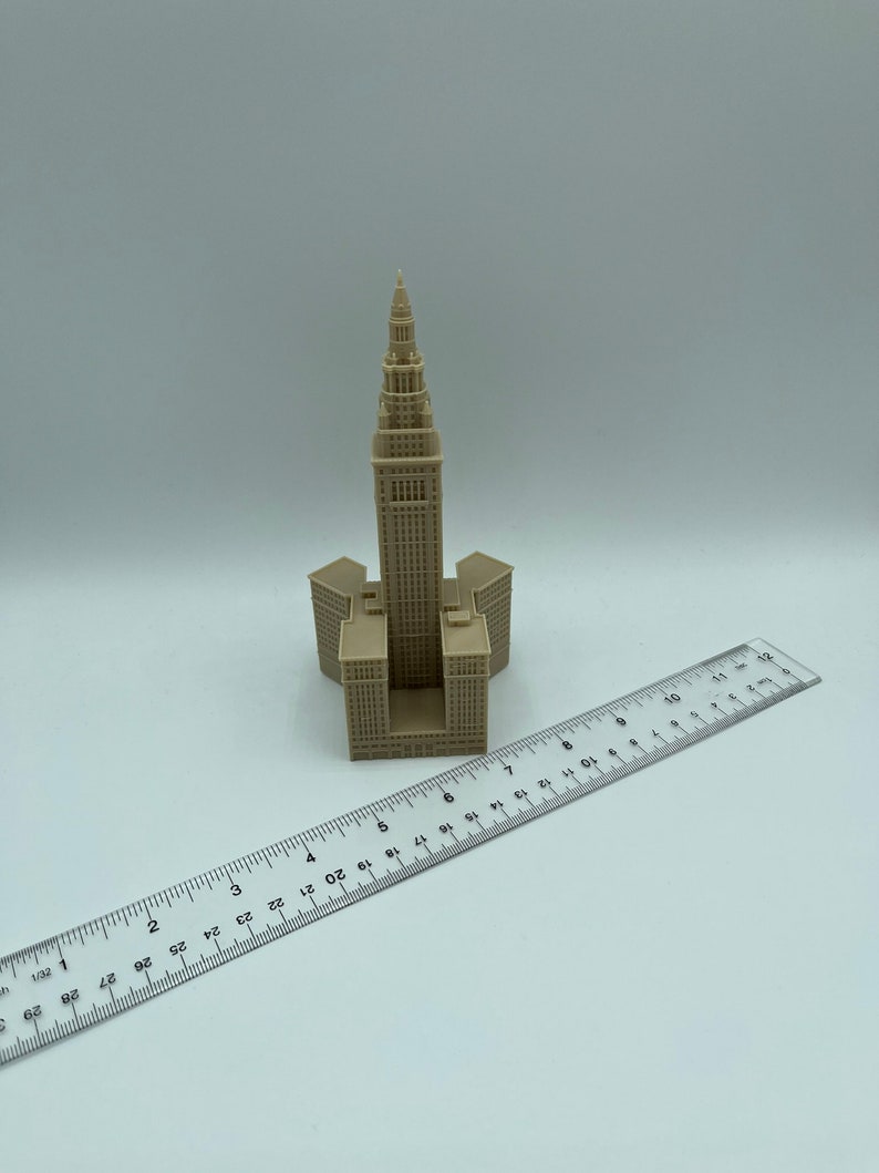 May include: A beige 3D printed model of the Terminal Tower in Cleveland, Ohio. The model is approximately 6 inches tall and is sitting on a white surface next to a ruler.