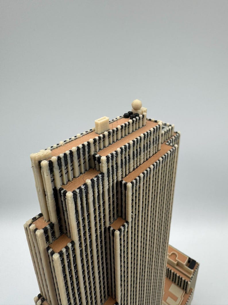 Puede incluir: Maqueta arquitect&oacute;nica detallada de un rascacielos. El edificio presenta una fachada color crema con detalles negros verticales y bandas horizontales de color marr&oacute;n. El modelo tiene un techo plano con peque&ntilde;os detalles arquitect&oacute;nicos.