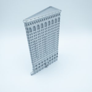 Puede incluir: Un modelo de rascacielos gris impreso en 3D con un techo triangular y muchas ventanas.