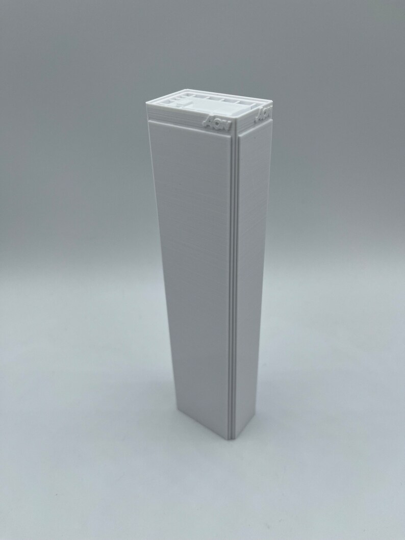 K&ouml;nnte beinhalten: Ein wei&szlig;es 3D-gedrucktes Modell eines Wolkenkratzers mit dem Text "4CM" auf der Oberseite.