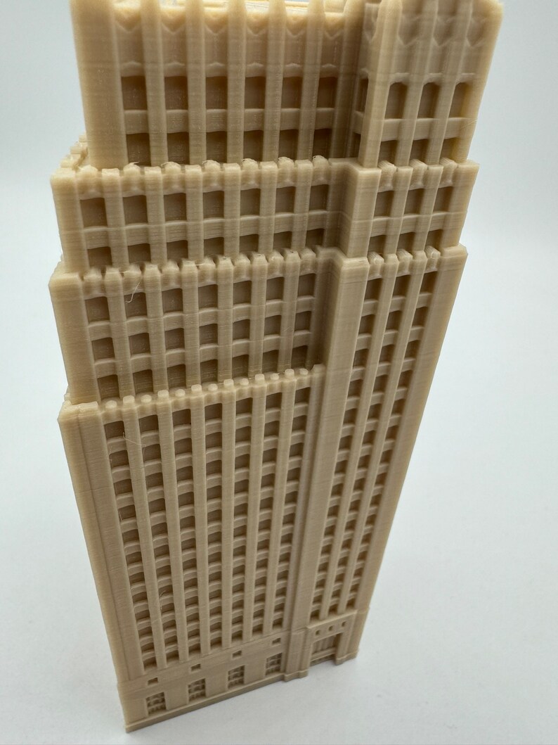 Pu&ograve; includere: Un modello 3D stampato in beige di un edificio alto con molte finestre e una facciata dettagliata.