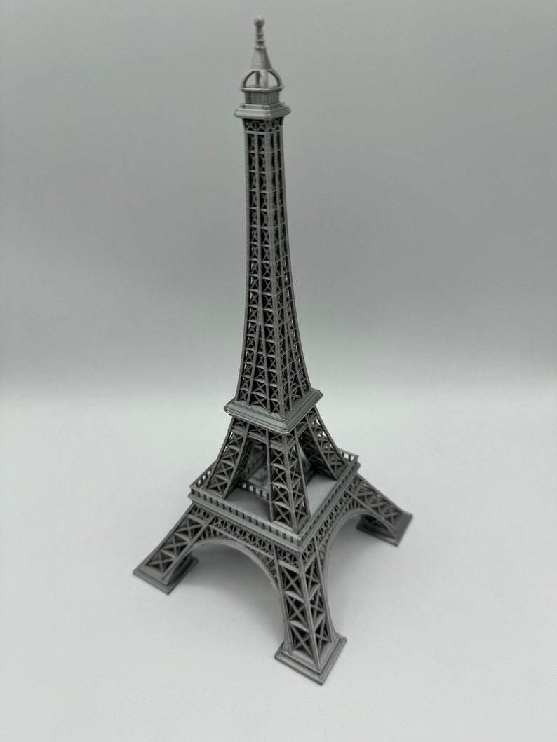 May include: A gray metal model of the Eiffel Tower. The model is detailed and has a realistic design.
