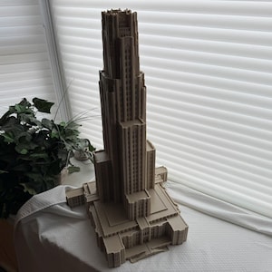 Puede incluir: Un modelo detallado de un edificio alto de color beige con muchas ventanas y detalles intrincados. El modelo est&aacute; hecho de pl&aacute;stico y est&aacute; sentado sobre una superficie blanca.