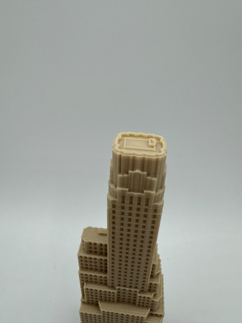 May include: A beige 3D printed model of a skyscraper with a flat roof and many windows.