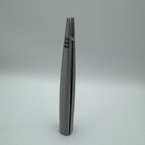 May include: A 3D printed model of a skyscraper, with a gray finish and a detailed facade.