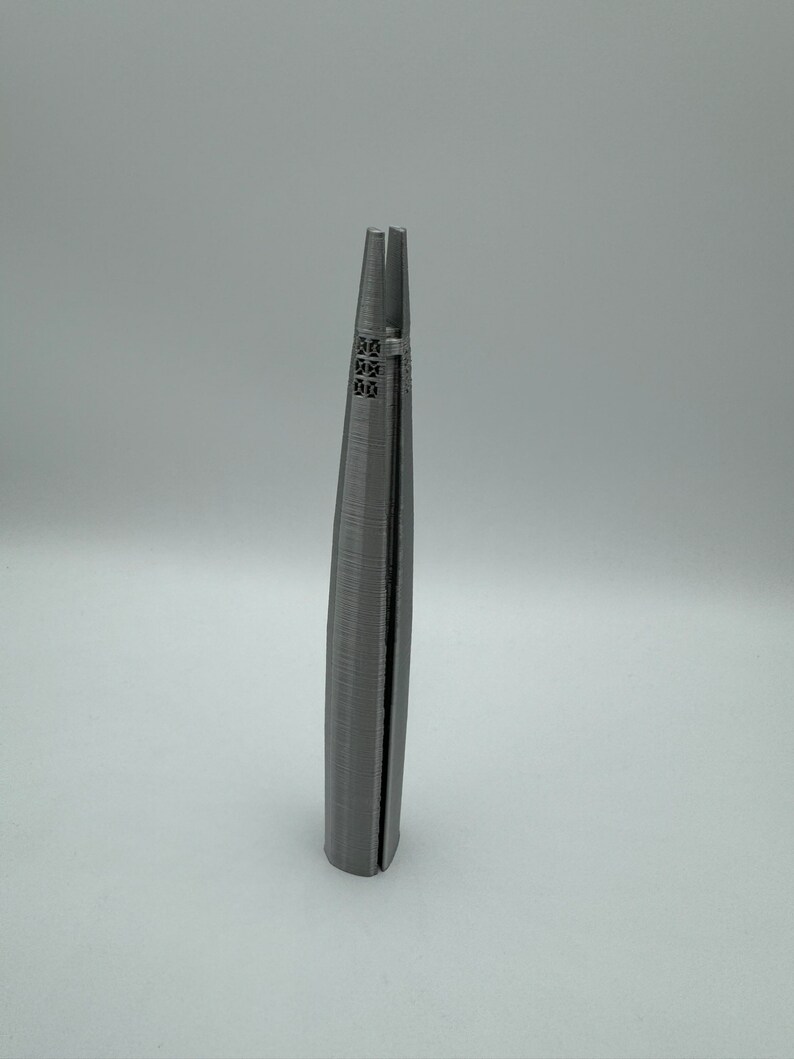 May include: A 3D printed model of a skyscraper, with a gray finish and a detailed facade.