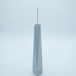 May include: A gray model of the One World Trade Center building with a pointed spire on top.