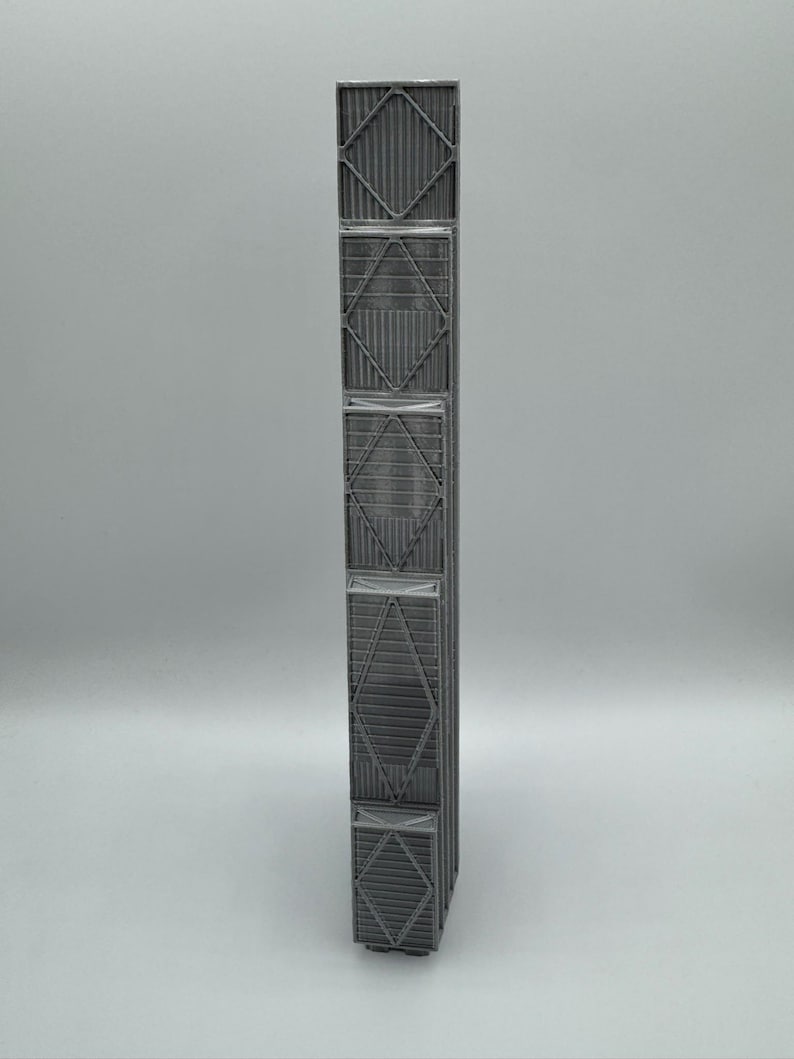 May include: A tall, narrow, gray rectangular column featuring a repeating structural pattern of vertical slats and diagonal cross-bracing. The object has a matte finish and a modular design with five distinct stacked sections, each framed by rigid borders.