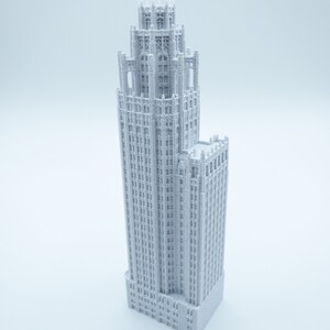 May include: A white 3D printed model of a tall, slender building with a decorative top and many windows.