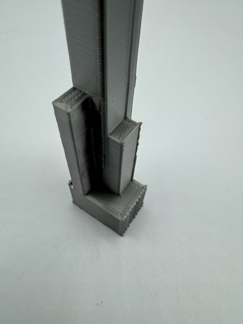 Op de afbeelding: Een 3D-geprint model van een wolkenkrabber, in grijze kleur met een textuur.