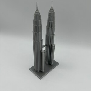 May include: A gray 3D printed model of the Petronas Towers, a famous landmark in Kuala Lumpur, Malaysia.