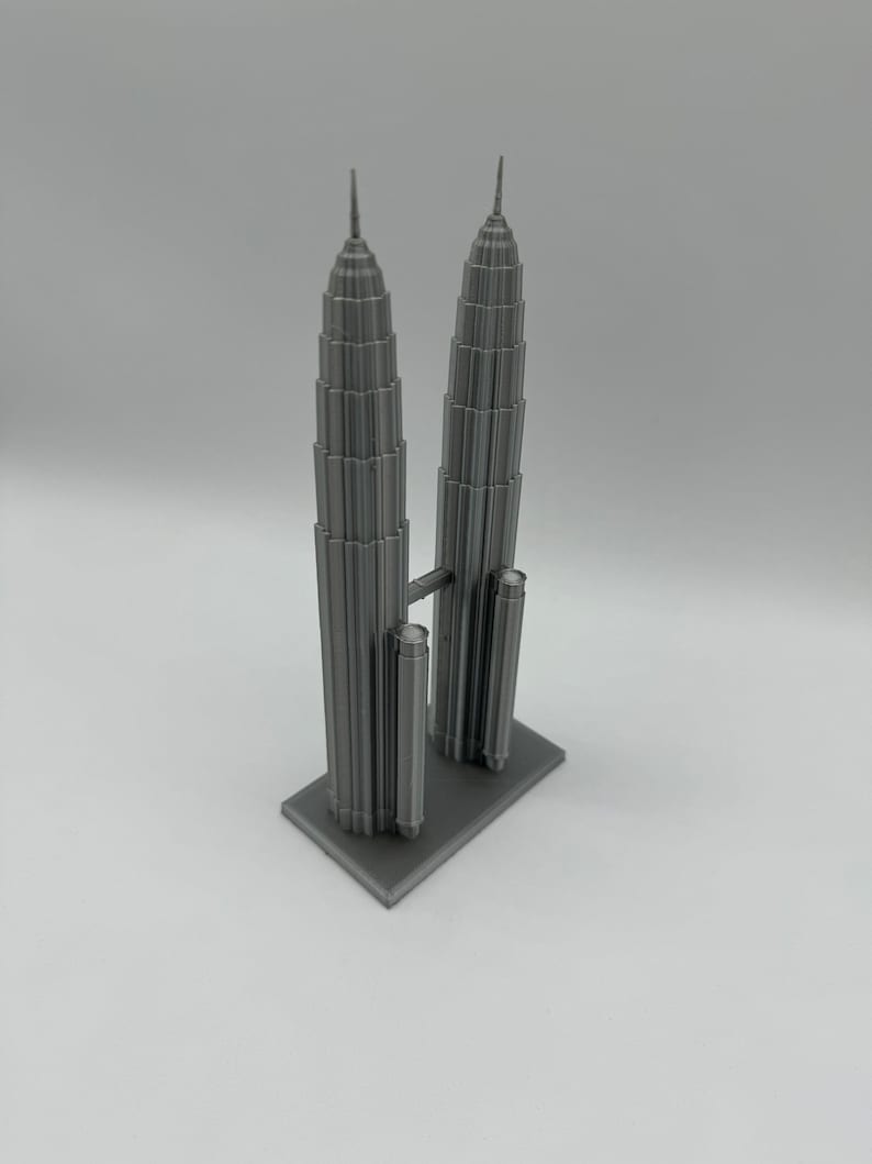May include: A gray 3D printed model of the Petronas Towers, a famous landmark in Kuala Lumpur, Malaysia.