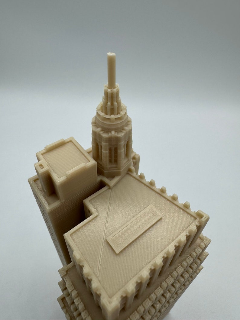 Pu&ograve; includere: Un modello 3D stampato di un edificio con un'alta guglia appuntita. L'edificio &egrave; realizzato in plastica beige chiaro e ha una facciata dettagliata.