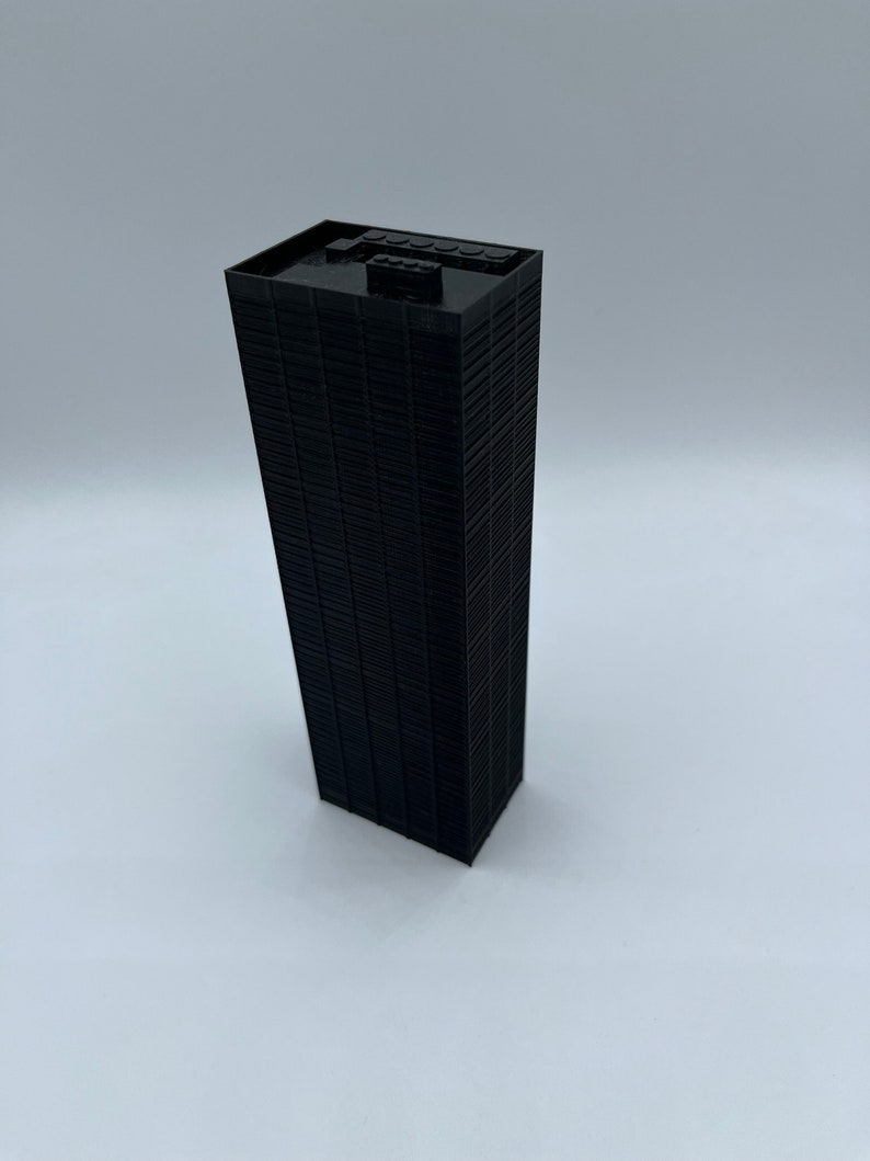 May include: A black Lego model of a skyscraper building.