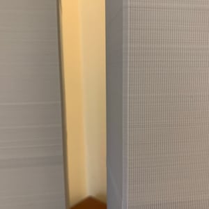May include: Close-up of two grey textured surfaces, likely fabric, with a narrow gap between them. The surfaces have a subtle pattern of small lines.