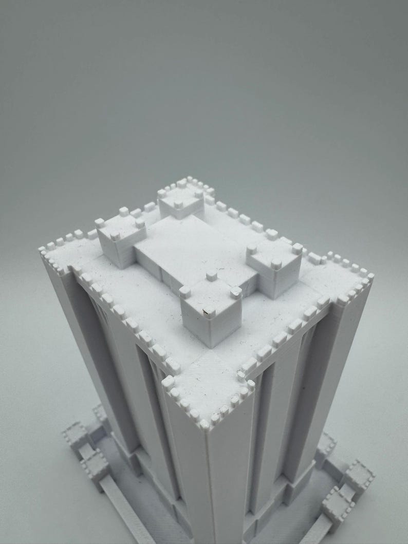 May include: White 3D printed model of a tall building with a crenellated roof and walls. The building has a square base and is made of a smooth, white plastic.