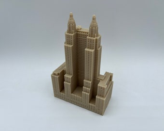 May include: A beige miniature model of a tall skyscraper with two towers. The model is made of plastic and has a detailed facade.