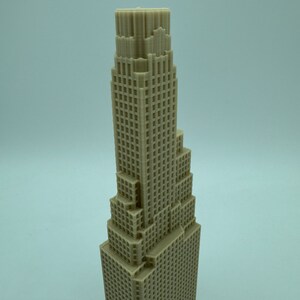 May include: A beige 3D printed model of a tall skyscraper with a detailed facade.