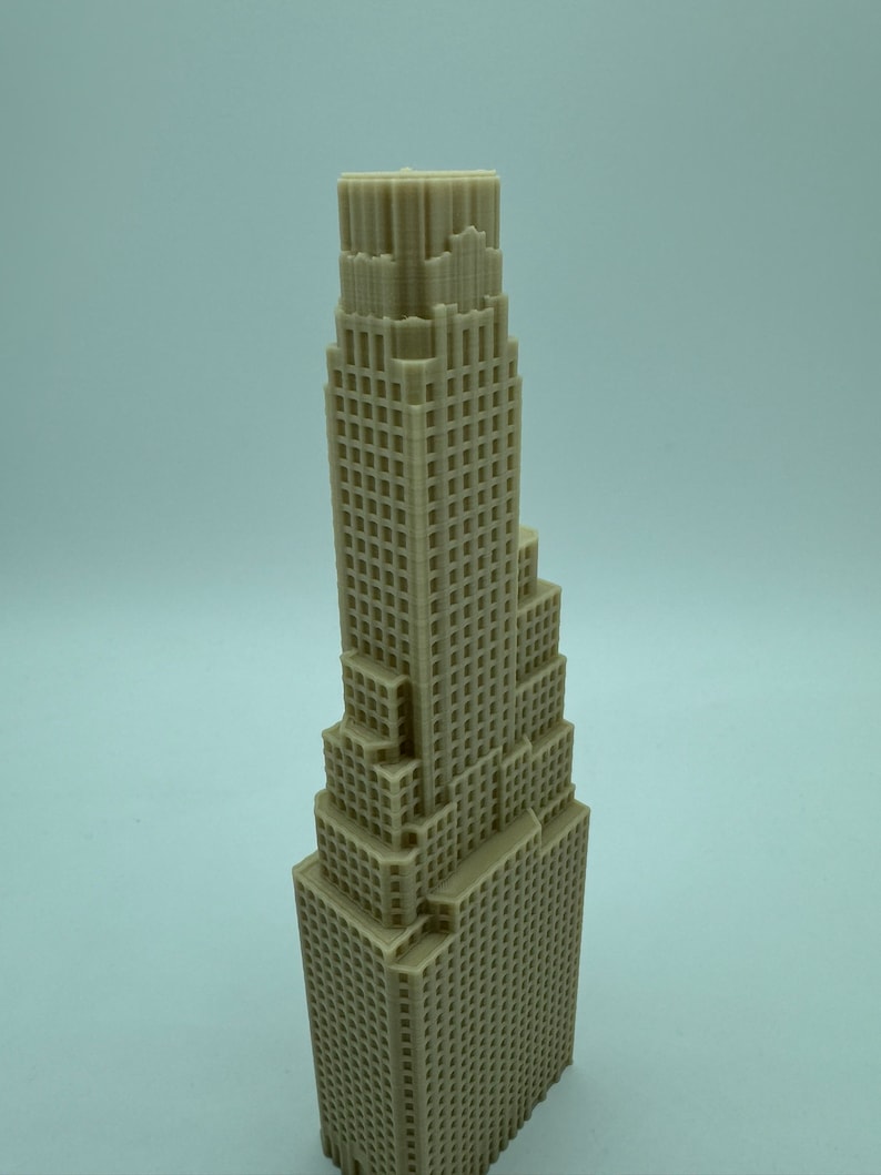 May include: A beige 3D printed model of a tall skyscraper with a detailed facade.