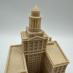 May include: A 3D printed model of a tall building with a domed roof. The building is beige and has many windows. The model is detailed and realistic.