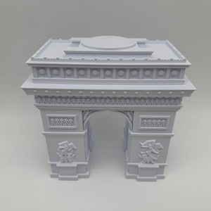 Może przedstawiać: Biała miniatura Łuku Triumfalnego. Model architektoniczny z precyzyjnymi rzeźbami i detalami. Łuk Triumfalny to klasyczny pomnik, idealny do ekspozycji.