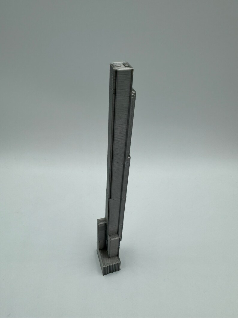 Op de afbeelding: Een grijs 3D-geprint model van een wolkenkrabber.