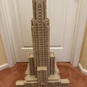 Puede incluir: Un modelo detallado de un edificio alto de color beige con un techo puntiagudo y muchas ventanas. El modelo est&aacute; hecho de pl&aacute;stico y mide aproximadamente 30 cm de alto.