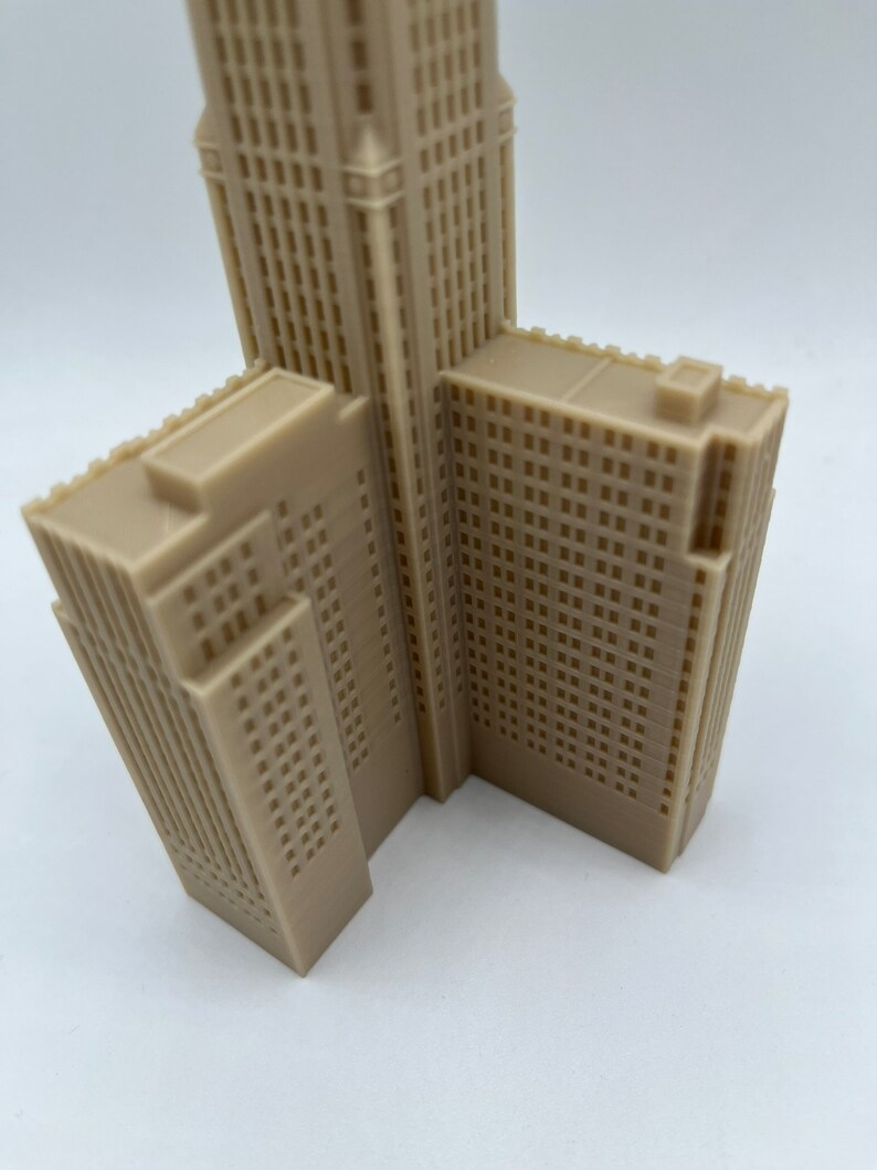 May include: A beige 3D printed model of a skyscraper with a detailed facade. The model is angled to show the side and front of the building.