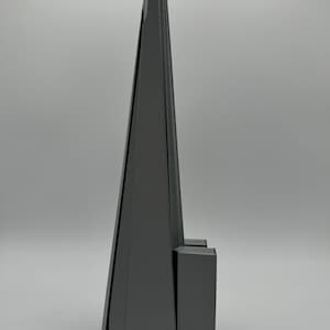 May include: A gray 3D printed model of a skyscraper with a pointed top and a rectangular base.