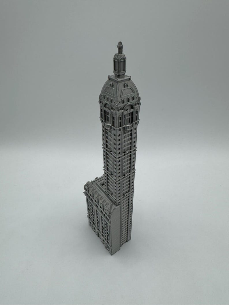May include: A gray 3D printed model of a tall, ornate building with a domed roof.