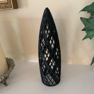 May include: A black, geometric, 3D printed, decorative object shaped like a tall, narrow cone with a diamond pattern.