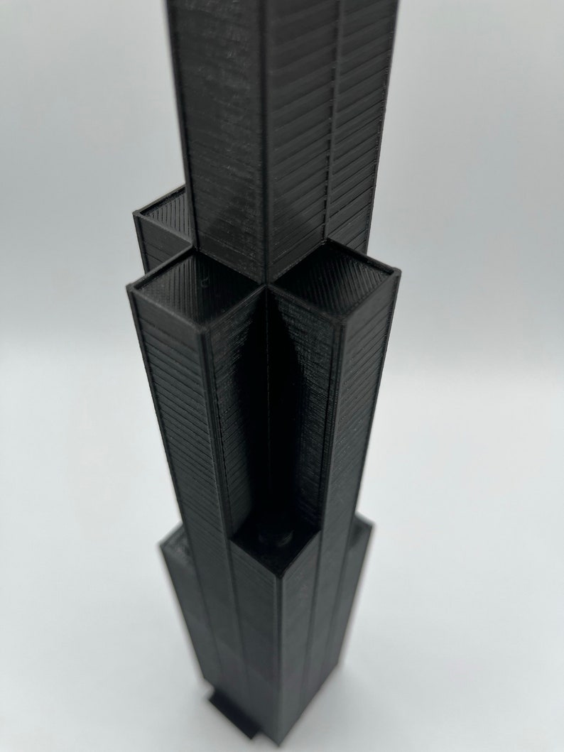 May include: A black 3D printed model of a skyscraper.
